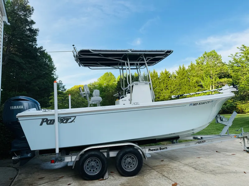 Slide: The Image of 2024 Parker 21 boat on trailer parked outdoors. - 2