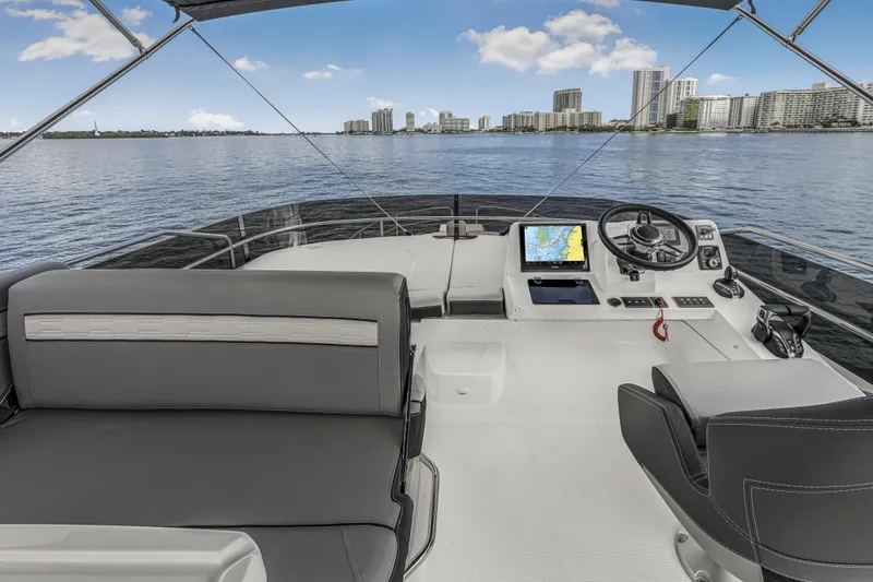 Slide: The Image of Flybridge of 2025 Jeanneau NC 1295 Fly yacht with city skyline view. - 12