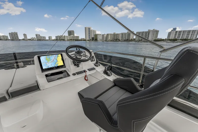 Slide: The Image of Helm of 2025 Jeanneau NC 1295 Fly yacht with city skyline view. - 14