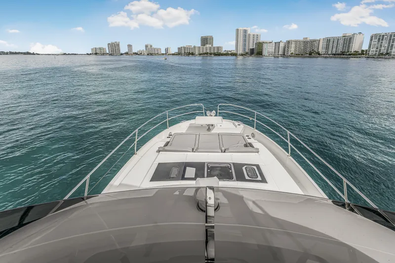 Slide: The Image of 2025 Jeanneau NC 1295 Fly yacht cruising near city skyline on calm waters. - 15
