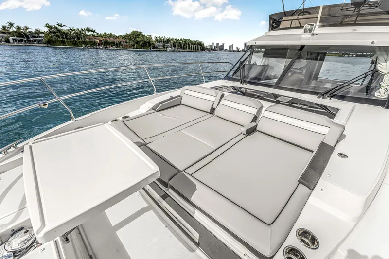 Slide: The Image of 2025 Jeanneau NC 1295 Fly yacht with sunbathing area, docked by scenic waterfront. - 18