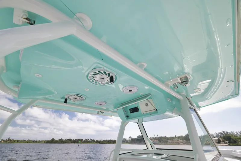 Slide: The Image of 2017 Yellowfin 39 Offshore boat with teal interior ceiling and speakers, on a sunny day. - 15