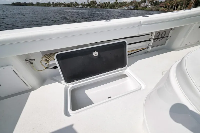 Slide: The Image of 2017 Yellowfin 39 Offshore boat deck with open storage compartment by the water. - 25