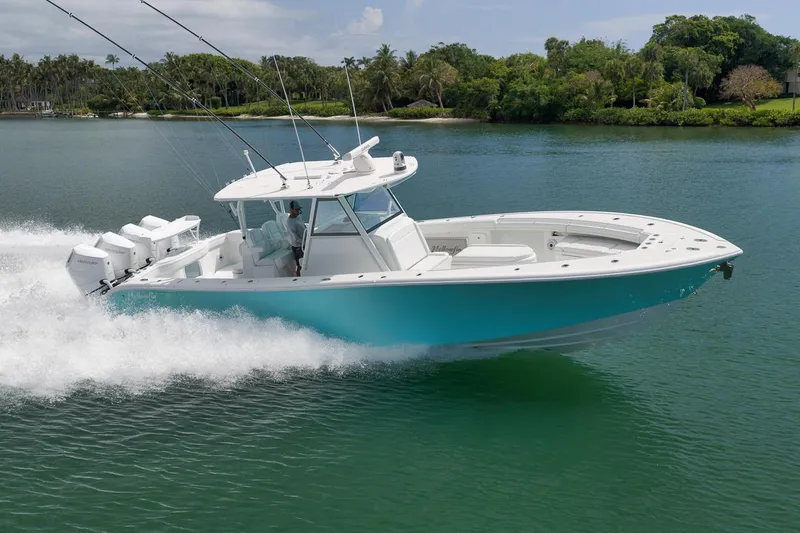 Slide: The Image of 2017 Yellowfin 39 Offshore boat cruising on a serene lake with lush greenery. - 29