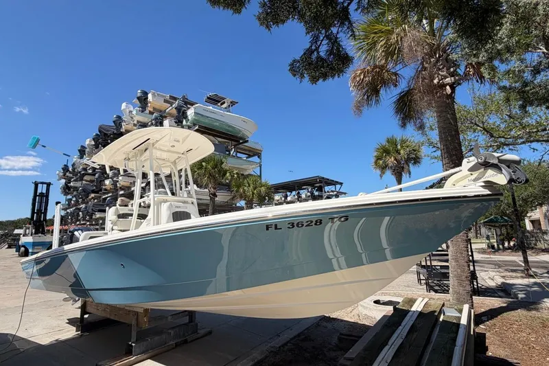 The Image of 2022 Pathfinder 2600 HPS boat docked, surrounded by palm trees and stacked boats. - 1