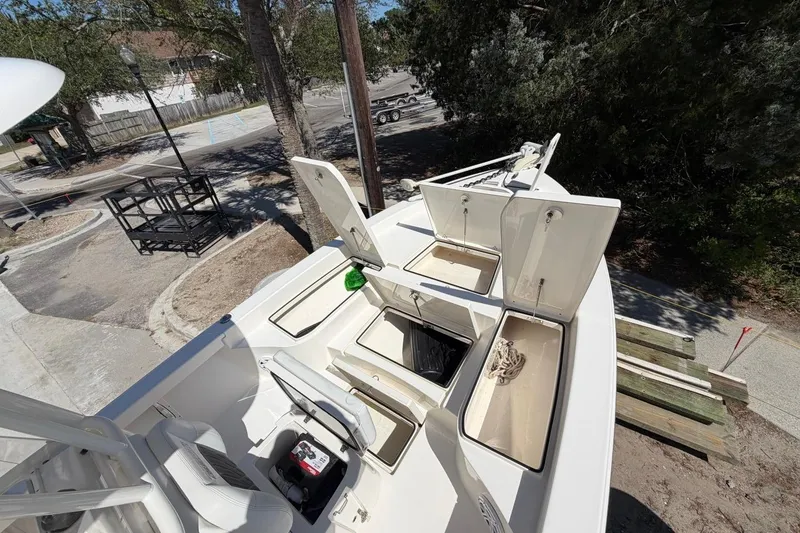 Slide: The Image of 2022 Pathfinder 2600 HPS boat with open storage compartments, parked outdoors. - 15