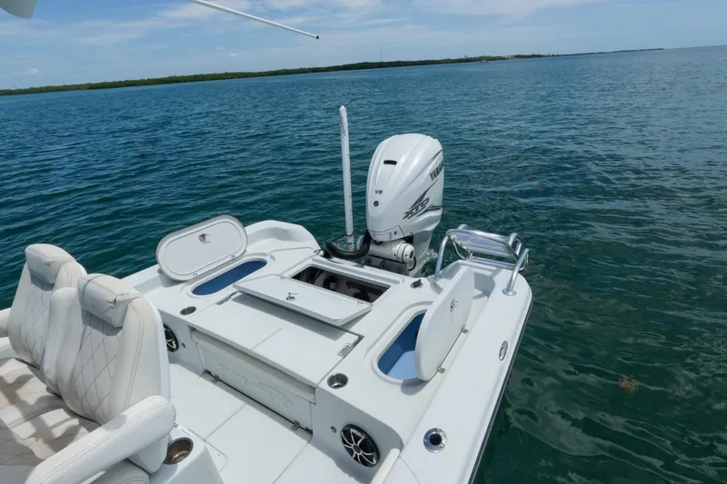 Slide: The Image of 2019 Blue Wave 2800 Pure Hybrid boat on calm water, featuring Yamaha V8 engine. - 12