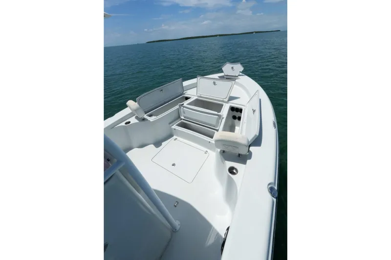 Slide: The Image of 2019 Blue Wave 2800 Pure Hybrid boat with open storage compartments on calm water. - 18
