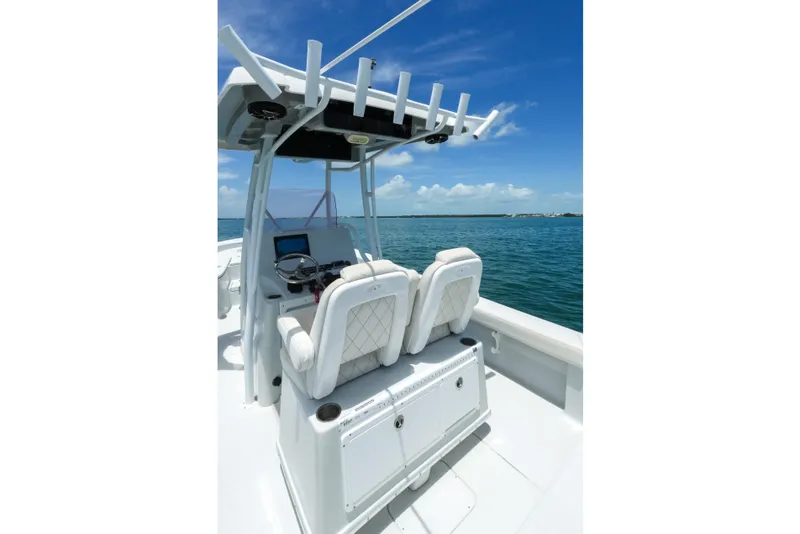 Slide: The Image of 2019 Blue Wave 2800 Pure Hybrid boat interior with helm and seating, on open water. - 22