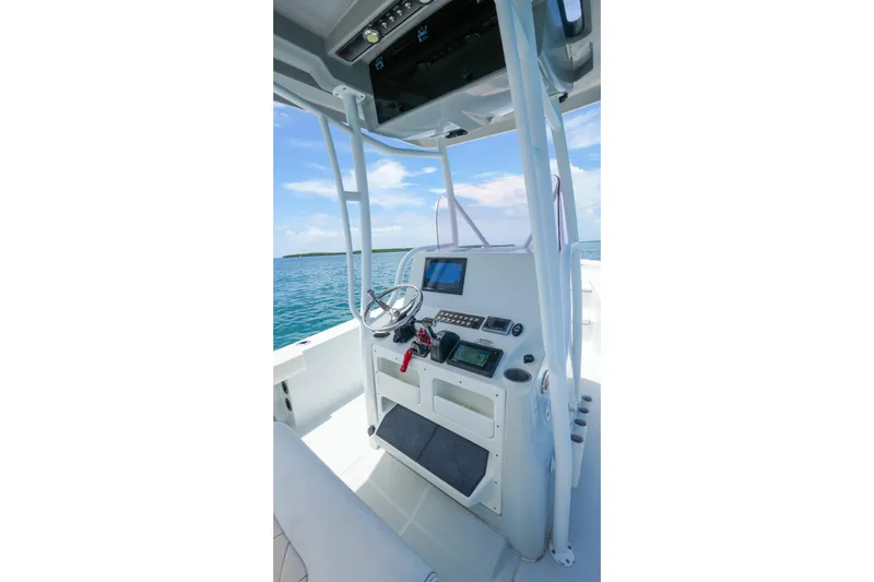 Slide: The Image of 2019 Blue Wave 2800 Pure Hybrid boat console with steering wheel and navigation screens. - 24