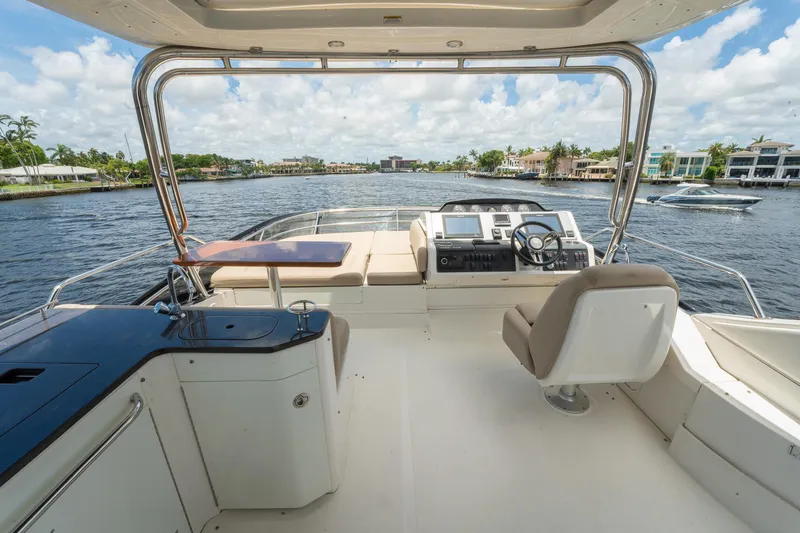Slide: The Image of 2016 Sea Ray 510 Flybridge yacht interior with helm, seating, and waterfront view. - 36