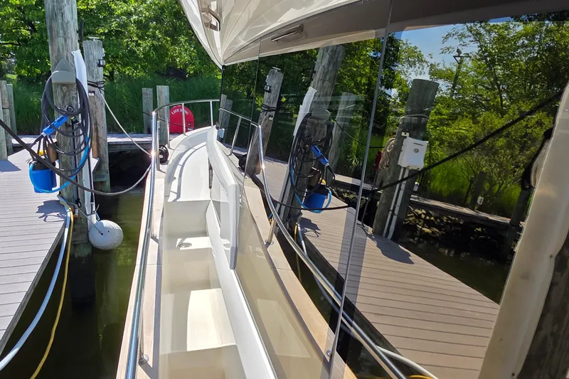 Slide: The Image of 2023 Greenline 40 yacht docked, reflecting lush greenery and marina surroundings. - 12