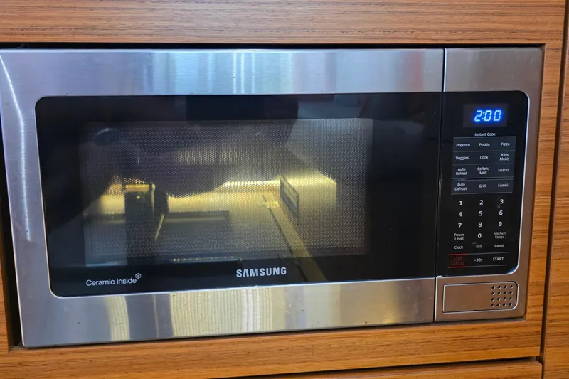 Slide: The Image of Modern Samsung microwave with digital display, set in a wooden kitchen cabinet. - 19
