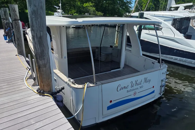 Slide: The Image of 2023 Greenline 40 boat docked, rear view, named "Come What May," in Baltimore, MD. - 3