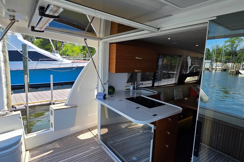 Slide: The Image of Modern Greenline 40 yacht interior with sleek kitchen, docked by serene waters, 2023 model. - 14
