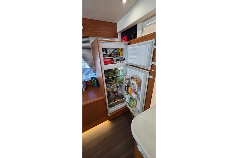 Slide: The Image of Open refrigerator in 2023 Greenline 40 yacht, stocked with various food items. - 21