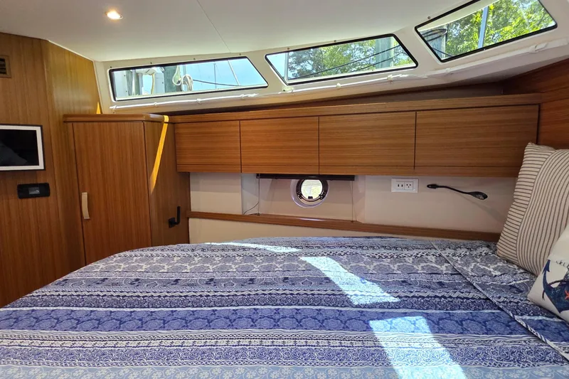 Slide: The Image of Luxurious cabin interior of 2023 Greenline 40 yacht with wood finish and patterned bedding. - 37