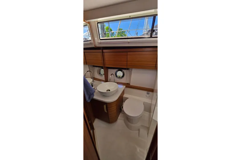 Slide: The Image of Modern bathroom interior of 2023 Greenline 40 yacht with wooden cabinetry and porthole windows. - 40