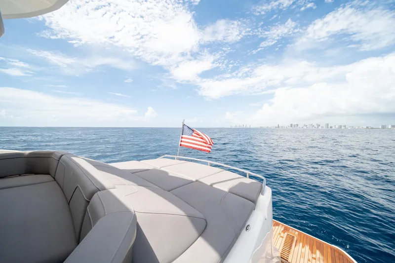 Slide: The Image of 2023 Princess S66 Sportbridge yacht with American flag, ocean view, and city skyline. - 7