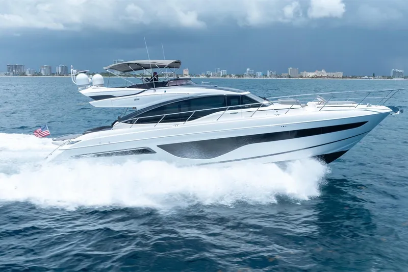 Slide: The Image of 2023 Princess S66 Sportbridge yacht cruising on open water, city skyline in background. - 38