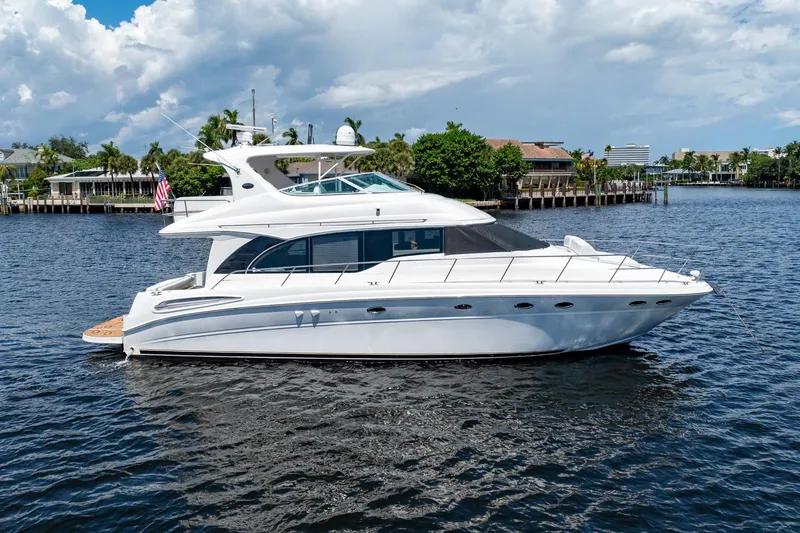 Slide: The Image of 2001 Sea Ray 540 Cockpit Motor Yacht on calm water, under a partly cloudy sky. - 4