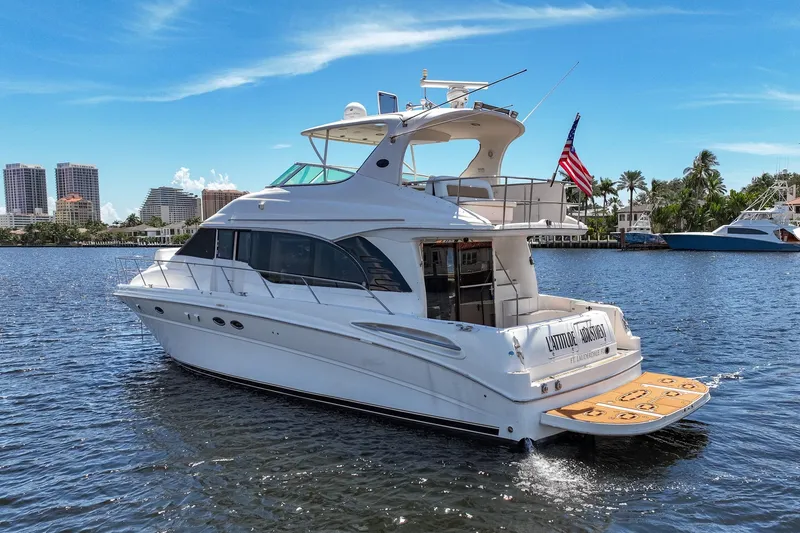 Slide: The Image of 2001 Sea Ray 540 Cockpit Motor Yacht cruising on a sunny day, city skyline in background. - 43