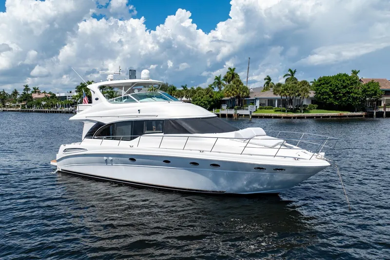 Slide: The Image of 2001 Sea Ray 540 Cockpit Motor Yacht on calm water, under a partly cloudy sky. - 5