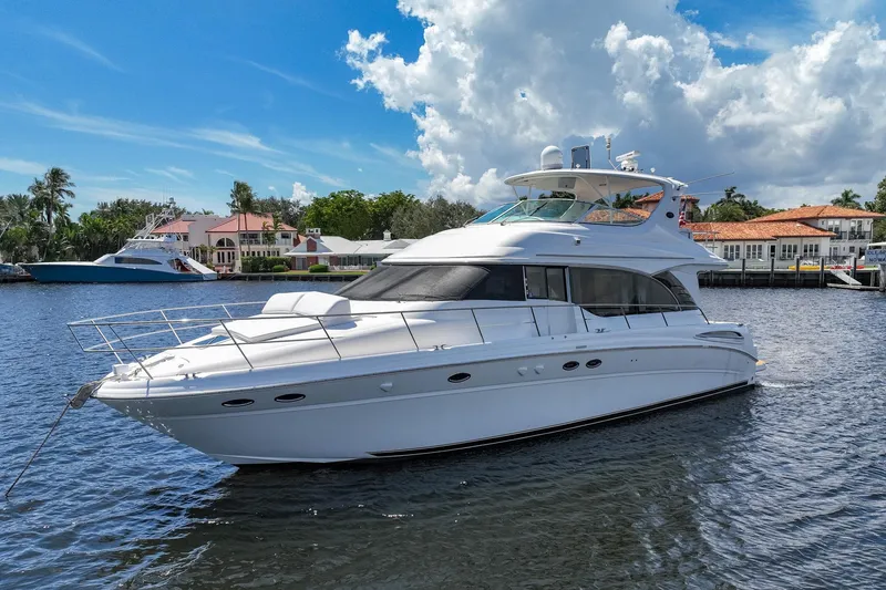 Slide: The Image of 2001 Sea Ray 540 Cockpit Motor Yacht on a sunny day, docked near waterfront homes. - 6