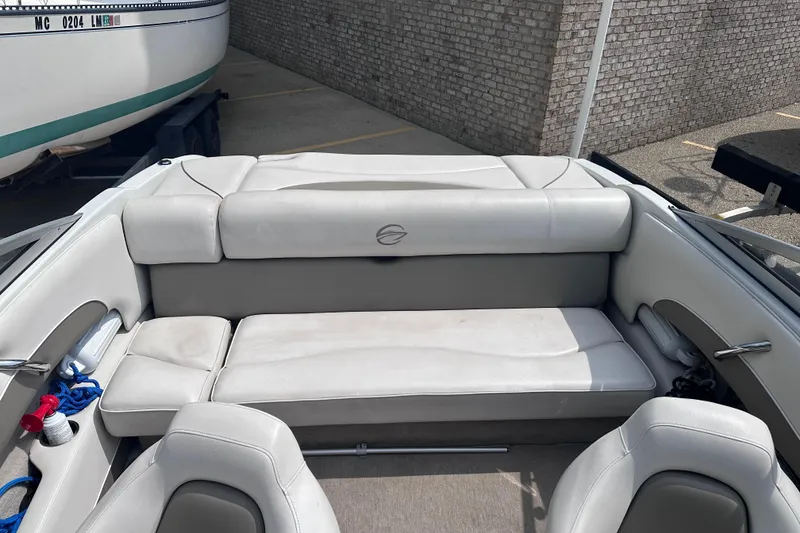Slide: The Image of 2015 Crownline 21 SS boat interior with white seating and storage compartments. - 10