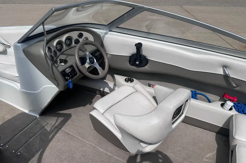 Slide: The Image of Interior of a 2015 Crownline 21 SS boat, featuring steering wheel and dashboard controls. - 12