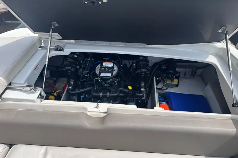 Slide: The Image of 2015 Crownline 21 SS boat engine compartment with open hatch, showcasing engine components. - 18