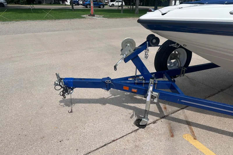 Slide: The Image of 2015 Crownline 21 SS boat on a blue trailer in a parking lot. - 4