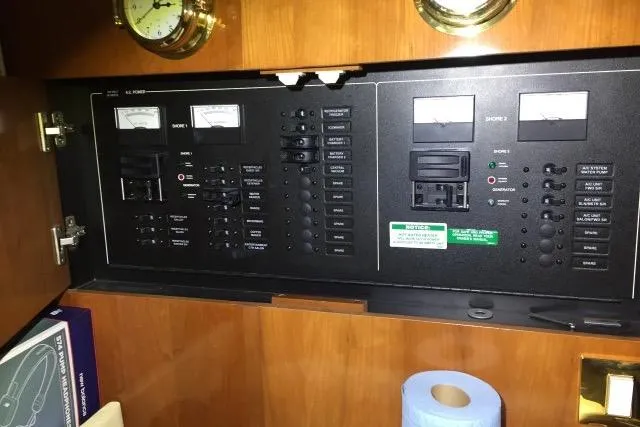 Slide: The Image of Electrical control panel inside a 2004 Carver 420 Mariner yacht, featuring gauges and switches. - 12