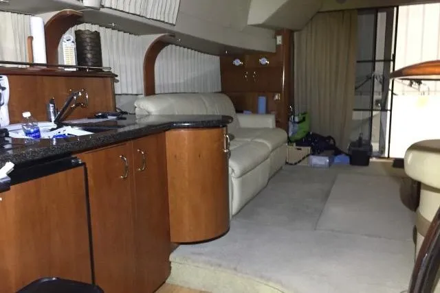 Slide: The Image of Interior of 2004 Carver 420 Mariner yacht with leather seating and wooden cabinetry. - 6