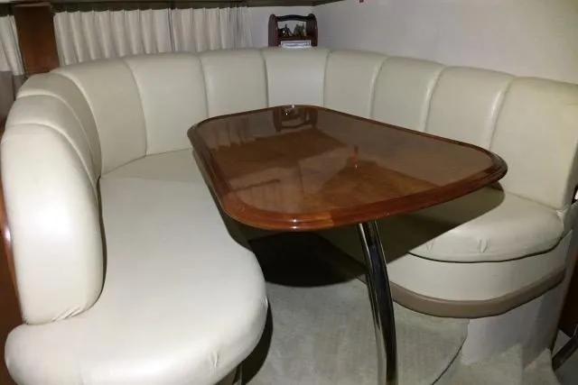Slide: The Image of Luxurious dining area in 2004 Carver 420 Mariner yacht with plush seating and wooden table. - 9