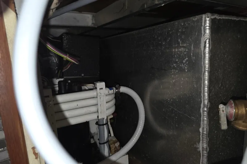 Slide: The Image of Engine compartment of a 1988 Marinette 37 Motor Yacht, showing pipes and metal components. - 31