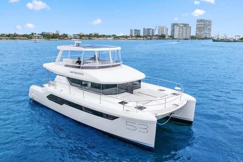 The Image of 2025 Leopard 53 Powercat yacht cruising on blue ocean near city skyline. - 0