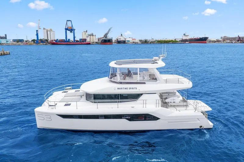 Slide: The Image of 2025 Leopard 53 Powercat yacht cruising in a harbor with industrial background. - 1