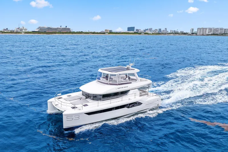 Slide: The Image of 2025 Leopard 53 Powercat cruising on blue ocean near city skyline. - 12