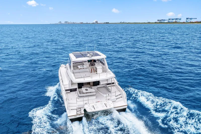 Slide: The Image of 2025 Leopard 53 Powercat cruising on open blue sea, distant shoreline visible. - 14