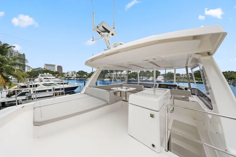 Slide: The Image of 2025 Leopard 53 Powercat yacht deck with seating, table, and marina view. - 68
