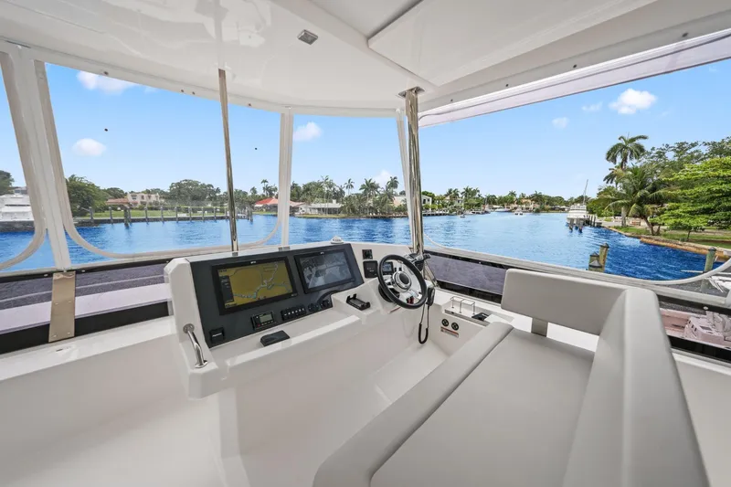 Slide: The Image of Helm of 2025 Leopard 53 Powercat overlooking serene waterfront view. - 73
