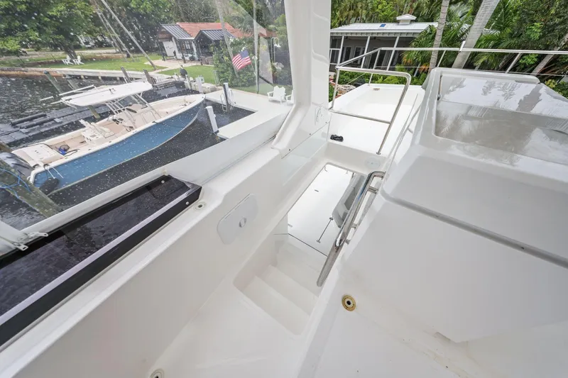 Slide: The Image of 2025 Leopard 53 Powercat yacht interior with sleek white design and marina view. - 77