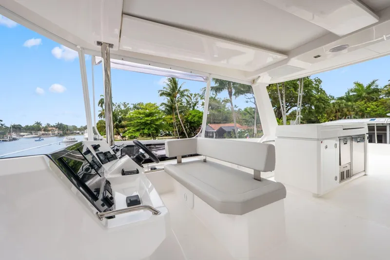 Slide: The Image of 2025 Leopard 53 Powercat interior with modern helm, seating, and lush waterfront view. - 84