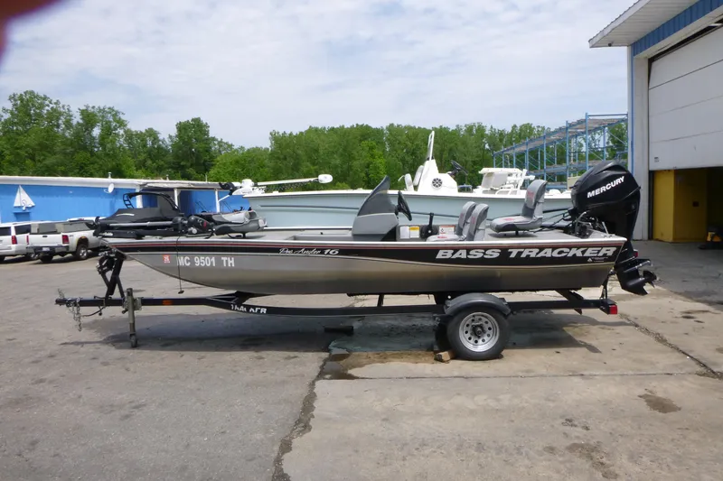The Image of 2011 Tracker Pro Angler 16 boat on trailer, parked outdoors near a blue building. - 1