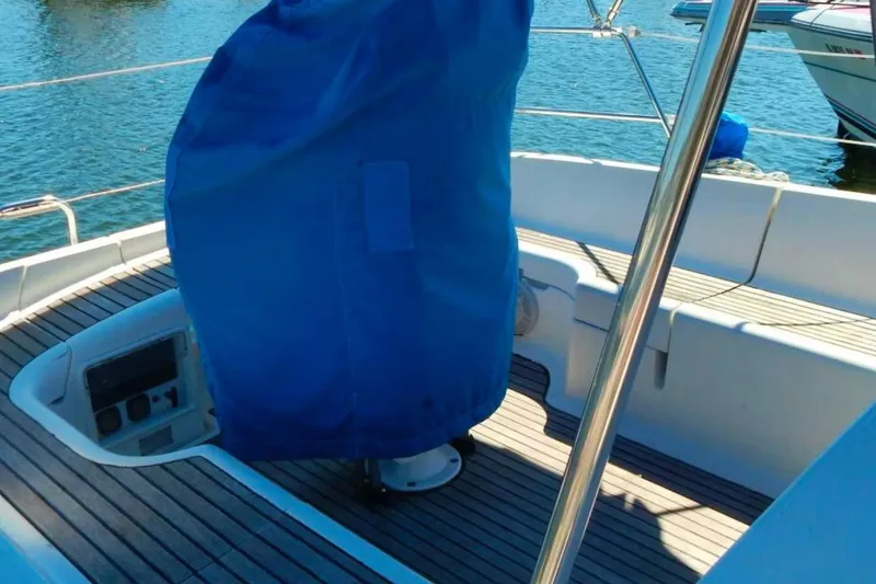 Slide: The Image of Cockpit of 1997 Jeanneau Sun Odyssey 36.2 sailboat with blue cover and wooden deck. - 3