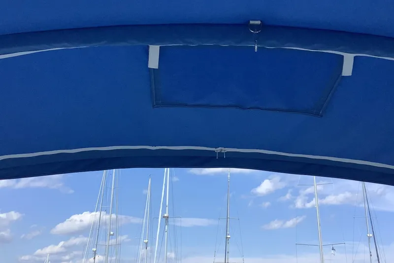 Slide: The Image of Blue canopy of a 1997 Jeanneau Sun Odyssey 36.2 sailboat with masts in the background. - 33