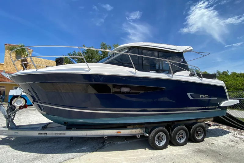 Slide: The Image of 2024 Jeanneau NC Weekender 895 Series 2 boat on trailer under clear blue sky. - 1