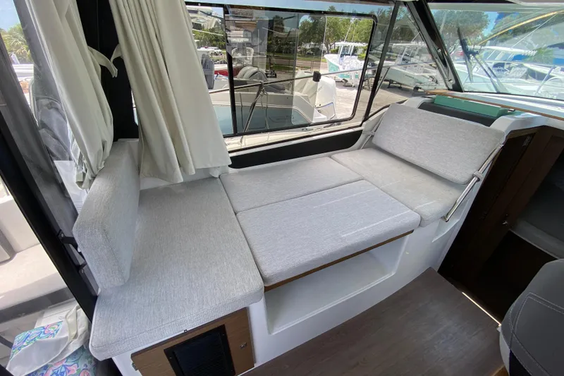 Slide: The Image of Interior of 2024 Jeanneau NC Weekender 895 Series 2 with convertible seating and large windows. - 13