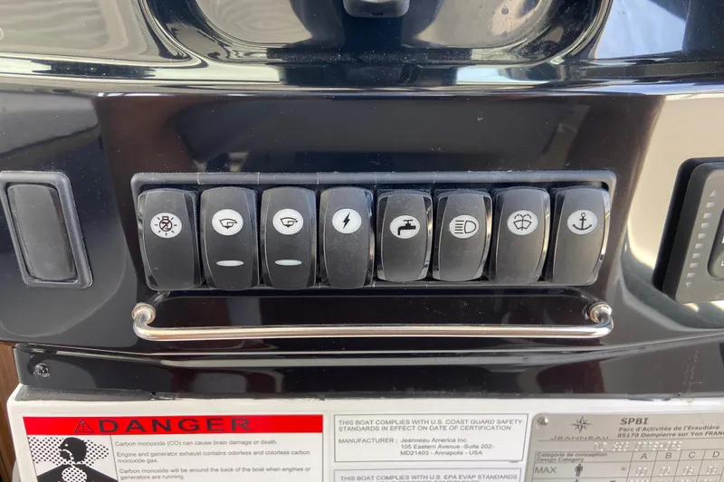 Slide: The Image of Control panel of 2024 Jeanneau NC Weekender 895 Series 2 with labeled switches and warning labels. - 17